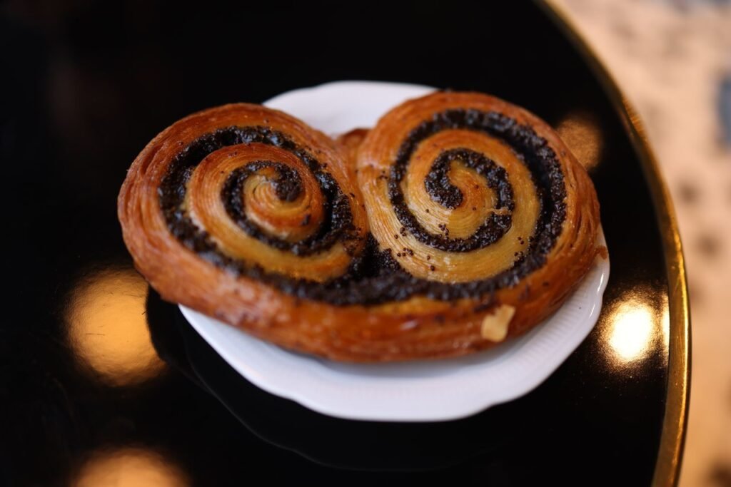 Close-up of a chocolate swirl pastry on a black and white plate, perfect for bakery themes.