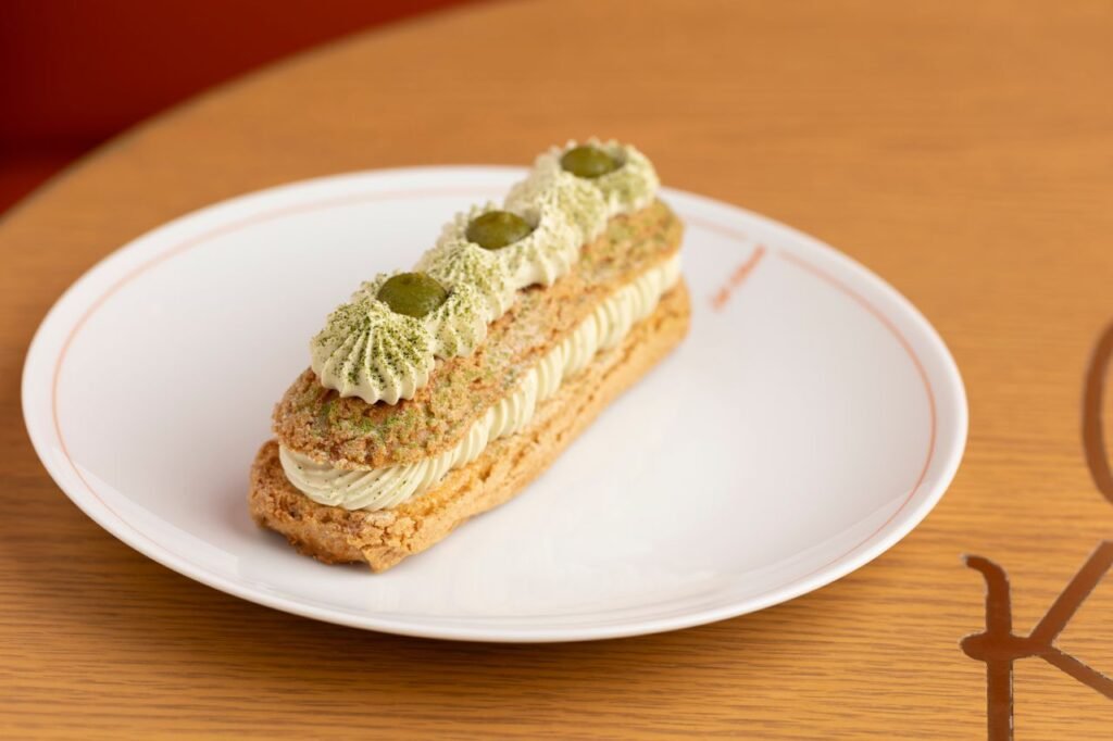 Tantalizing matcha cream eclair served on a white plate, perfect for dessert lovers.