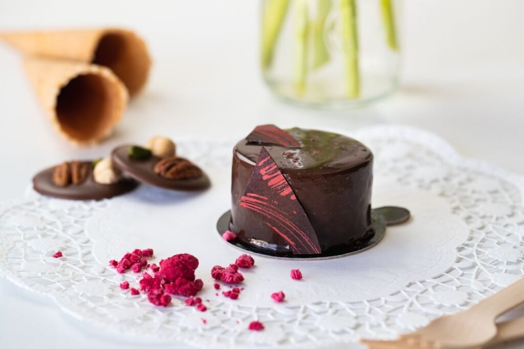 Indulge in a close-up of a gourmet chocolate cake with decorative berries and nuts.